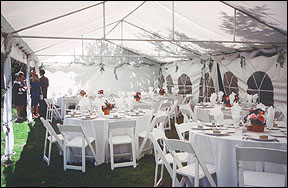 [Inside view of a tent at an outdoor wedding reception]